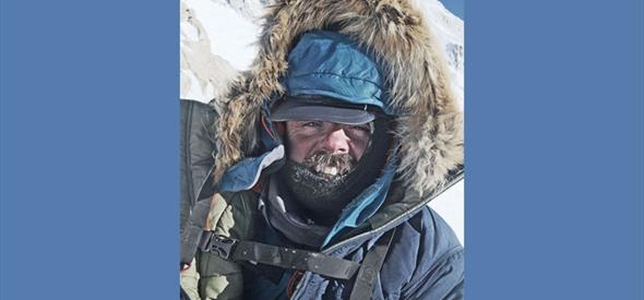 Man with a large winter jacket on a snowy mountain