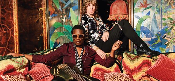Brand New Heavies sitting on a sofa