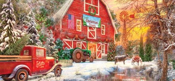 A red barn with a green tractor outside with snow on the ground and two cows in the background