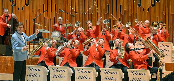 Orchestra players in red clothing playing instruments