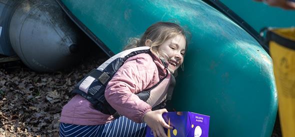 A young girl searching for Easter eggs during New Forest Activities Canoe Easter Egg Hunt