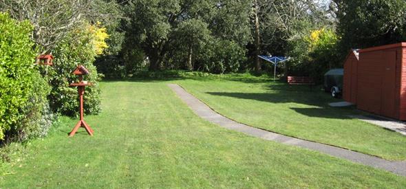 Garden with green grass and trees surrounding the garden