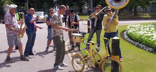 Group of men playing instruments outside on a sunny day
