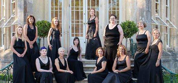 Goup of woman called La nova singers pose in front of highcliffe castle