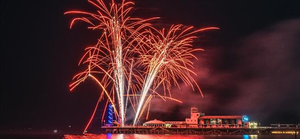 Image of a red firework going off over Bournemouth Pier