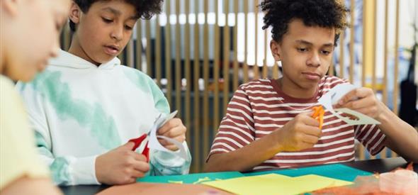 three children doing arts and crafts at a table