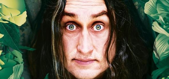 Ross Noble's face surrounded by green and yellow foliage