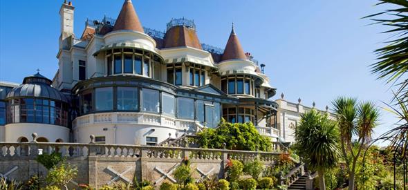 Victorian Villa with blue sky in the background and green lawn in the foreground