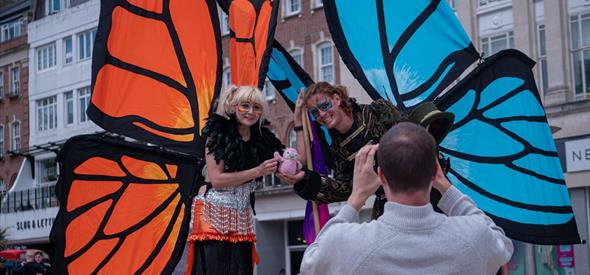 Giant butterfly characters posting for a photograph with the back of the photographer towards the camera