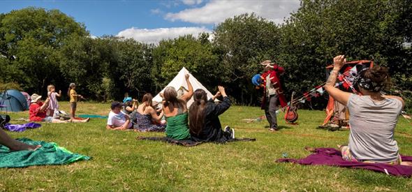 Families enjoying storytelling outdoors on blankets