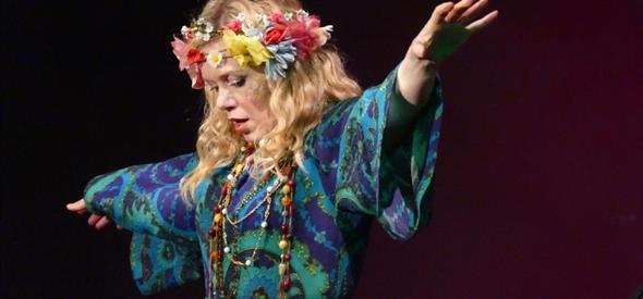 lady with flowers in her hair raising her arms at The Summer of Love concert