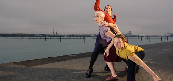 Image by Owen Benson of three women standing in a dance pose by the sea