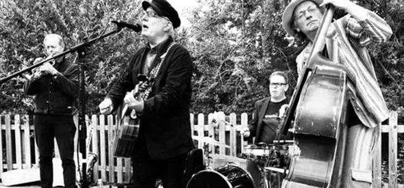 Black and white image of 4 musicians, with double bass in foreground, Vocalist centre and drums and brass in background