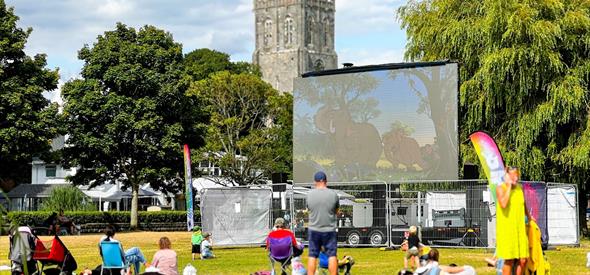 Big screen in Christchurch with the Priory in the background.