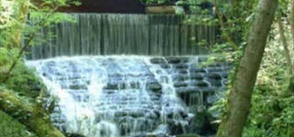 A bridge over cascading river at Chewton Bunny.