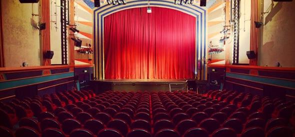 Red curtains on a stage with seats