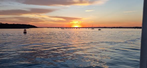 Sun setting with a red sky and the sea