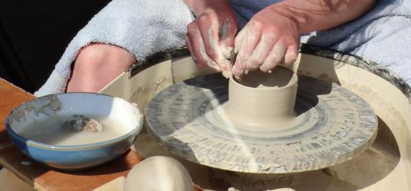 Person working on a piece of clay