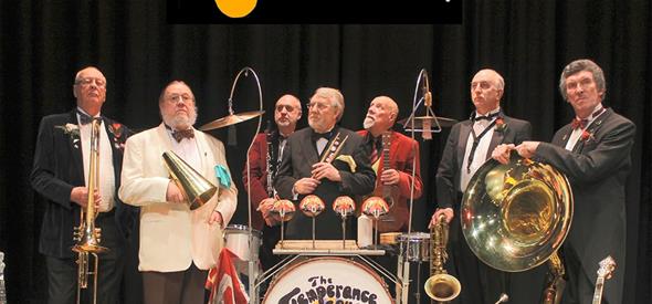 Seven men standing with instruments in their hands and one of the floor holding an instrument
