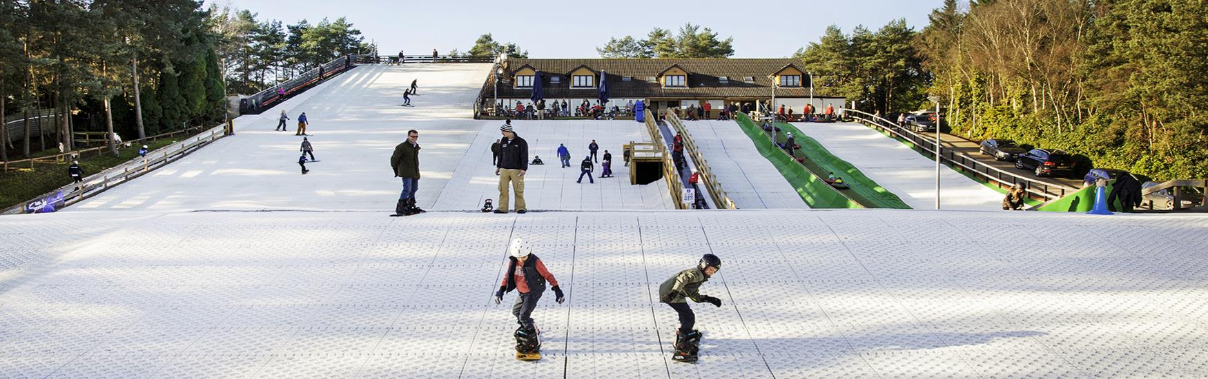 Children learning how to snowboard at Snowtrax