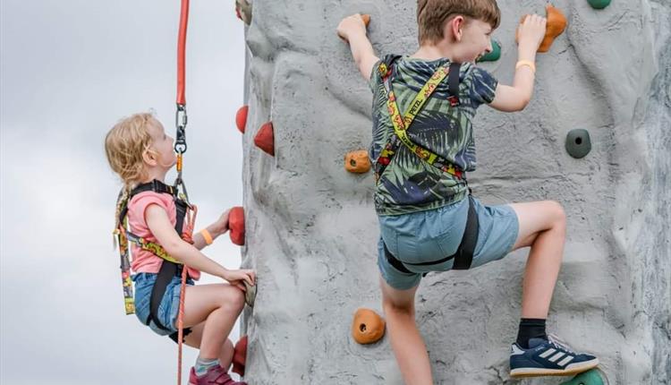Child, claiming on a rock wall