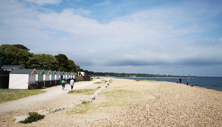 Wide shot of people walking on the dusty promenade at Avon Beach.
