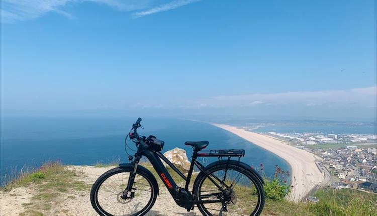 Electronic bike on a cliff overlooking the sea and beach