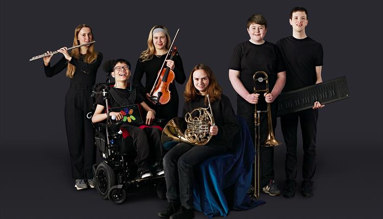 six members of the Youth Orchestra smiling with their instruments