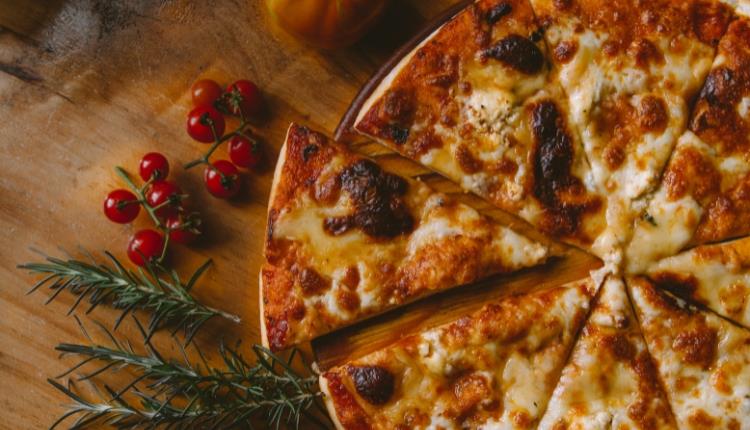 cheesy pizza on wooden table top
