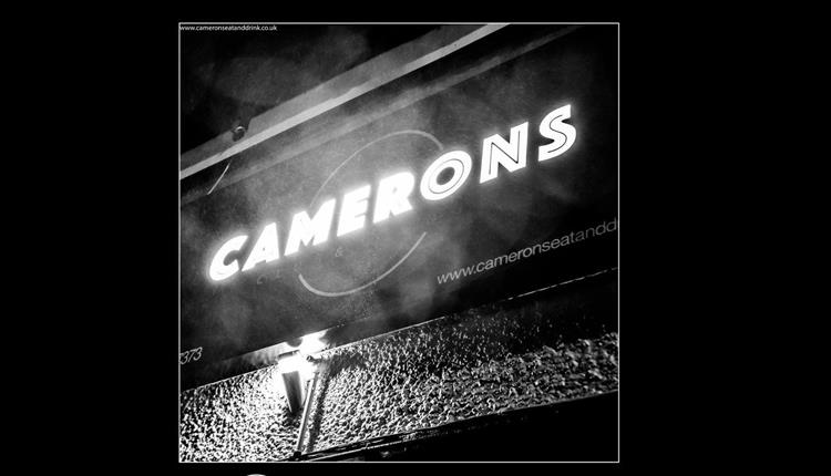Camerons lit up sign in black and white.