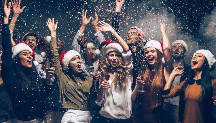 people with Santa hats dancing at an office party
