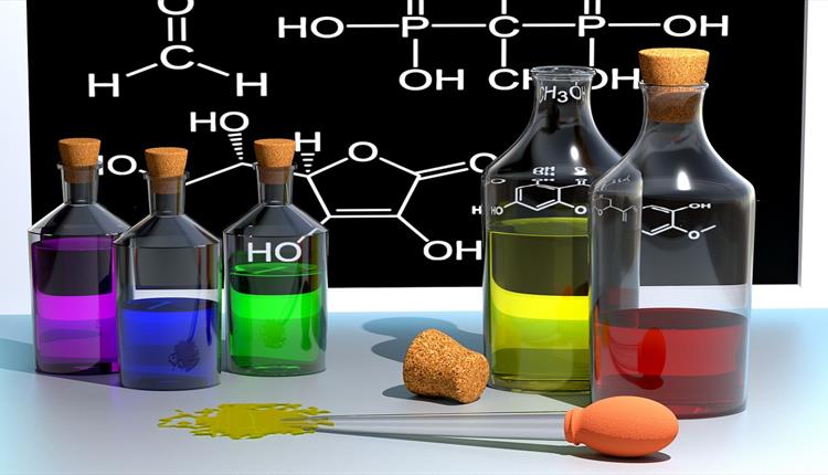 3D illustrated flasks with different coloured liquids and a formula in the background on a black board