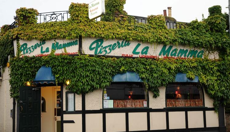 Outside of the restaurant with crawling vines over the facade.
