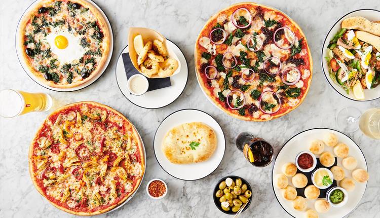 table of pizza and drinks laid out.