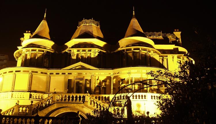 Exterior of Russell-Cotes illuminated at night by orange light