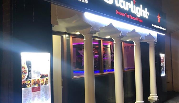 outside of the restaurant lit up at night.