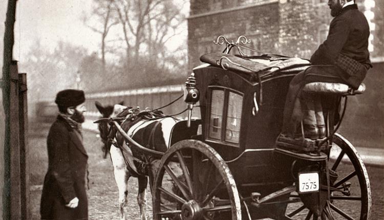 old time photograph of one man on a horse and buggy and another man standing in the street