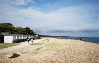 Wide shot of people walking on the dusty promenade at Avon Beach.