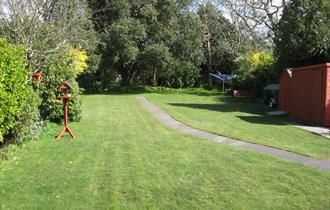 Garden with green grass and trees surrounding the garden