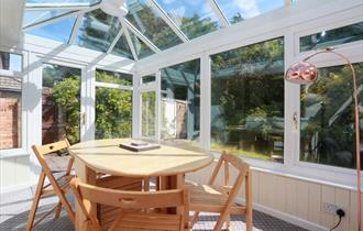 Bright conservatory with dining table and chairs