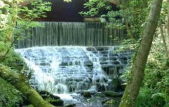 A bridge over cascading river at Chewton Bunny.