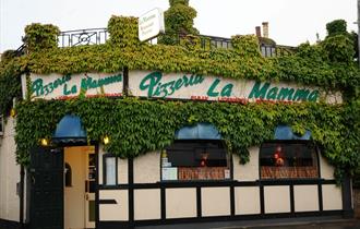 Outside of the restaurant with crawling vines over the facade.