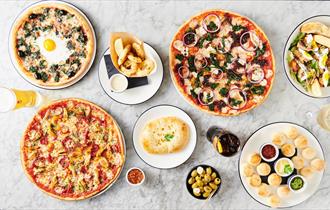table of pizza and drinks laid out.