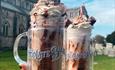 The famous ducking stool milkshakes held in front of the Christchurch priory