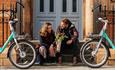 Couple sitting with two bikes parked next to them