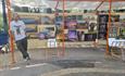 Man posing with his artwork stall at market