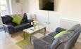 Modern cosy lounge area with green and grey furniture