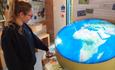 Lady pressing button to illuminate globe