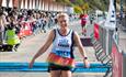 Lady running and smiling passing the finish line