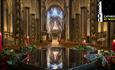 Inside Cathedral with candles, festive flowers and reflections